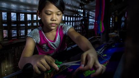 A girl cuts a piece of fabric