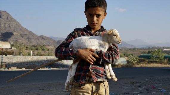 A boy holds a baby goat in a rural region of the Taiz mountains in southern Yemen.