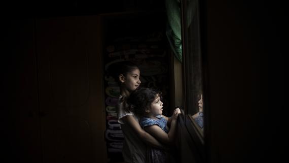 Two young girls look out the window