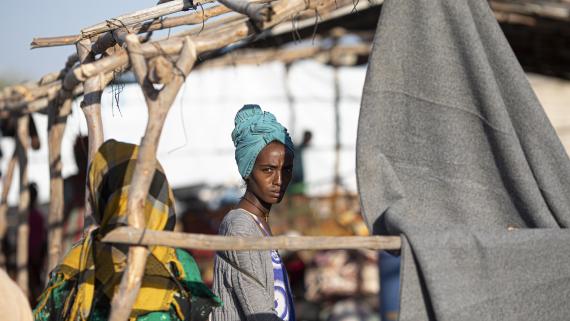 n Ethiopian woman stands in her temporary shelter at the Hamdayet border reception centre in Sudan.