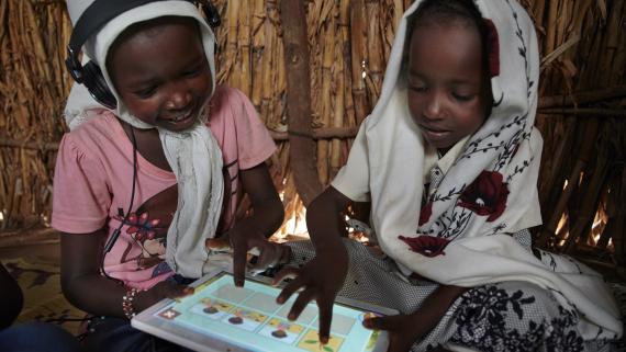 Two young girls use their tablet with educational content