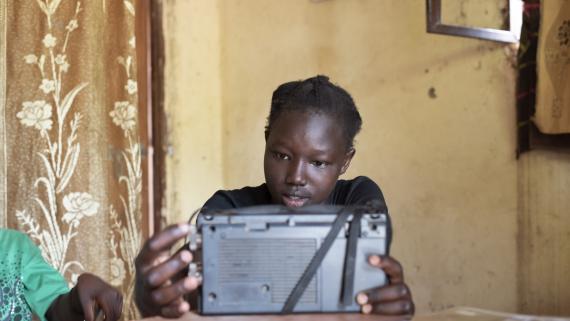 A girl listen to her school classes on the radio