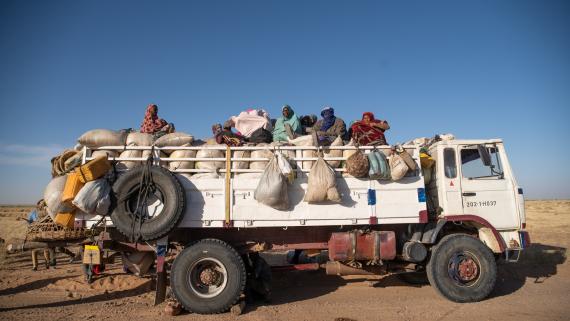 A group of women travel on the top of a truck