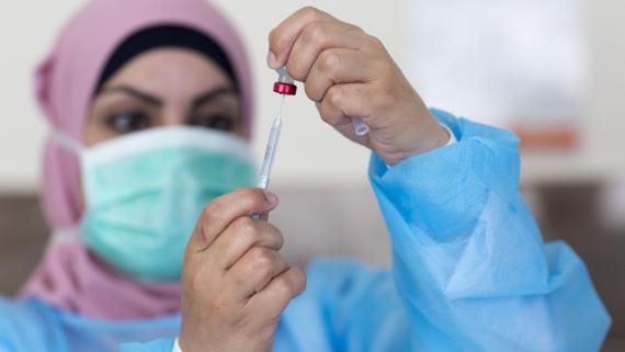 A nurse prepares a vaccine