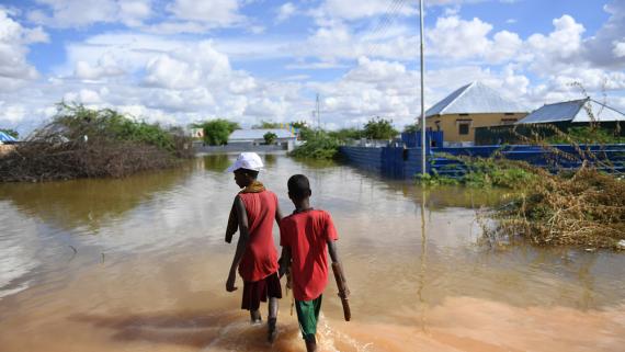 Two boys walking oalonger a flooded road