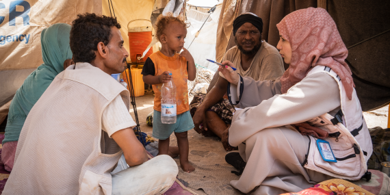 A woman conducts an assessment mission with a family