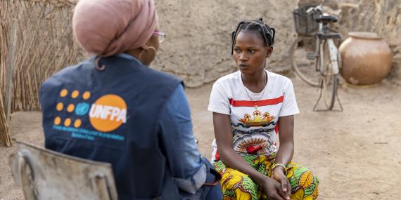A humanitarian worker talks to a young woman
